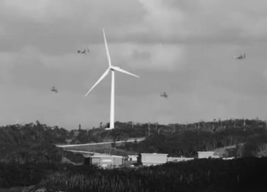 高さ107メートルの風車より低い高度で飛行する米海兵隊のMⅤ22オスプレイ4機＝2021年2月4日、奄美市名瀬大熊の風力発電所で。（写真提供＝「戦争のための自衛隊配備に反対する奄美ネット」）